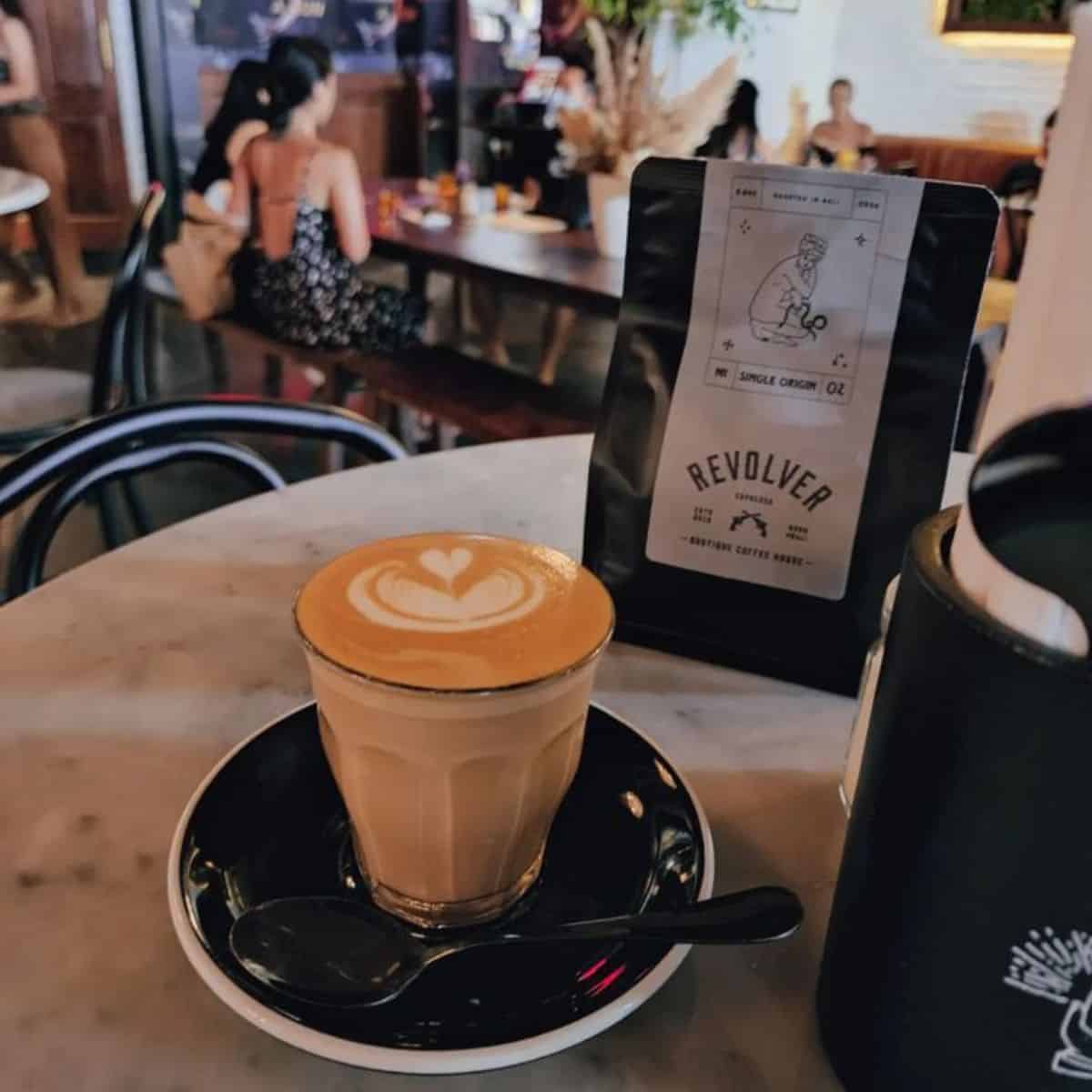 Revolver Coffee Hot Coffee Latte served on a black plate with a spoon