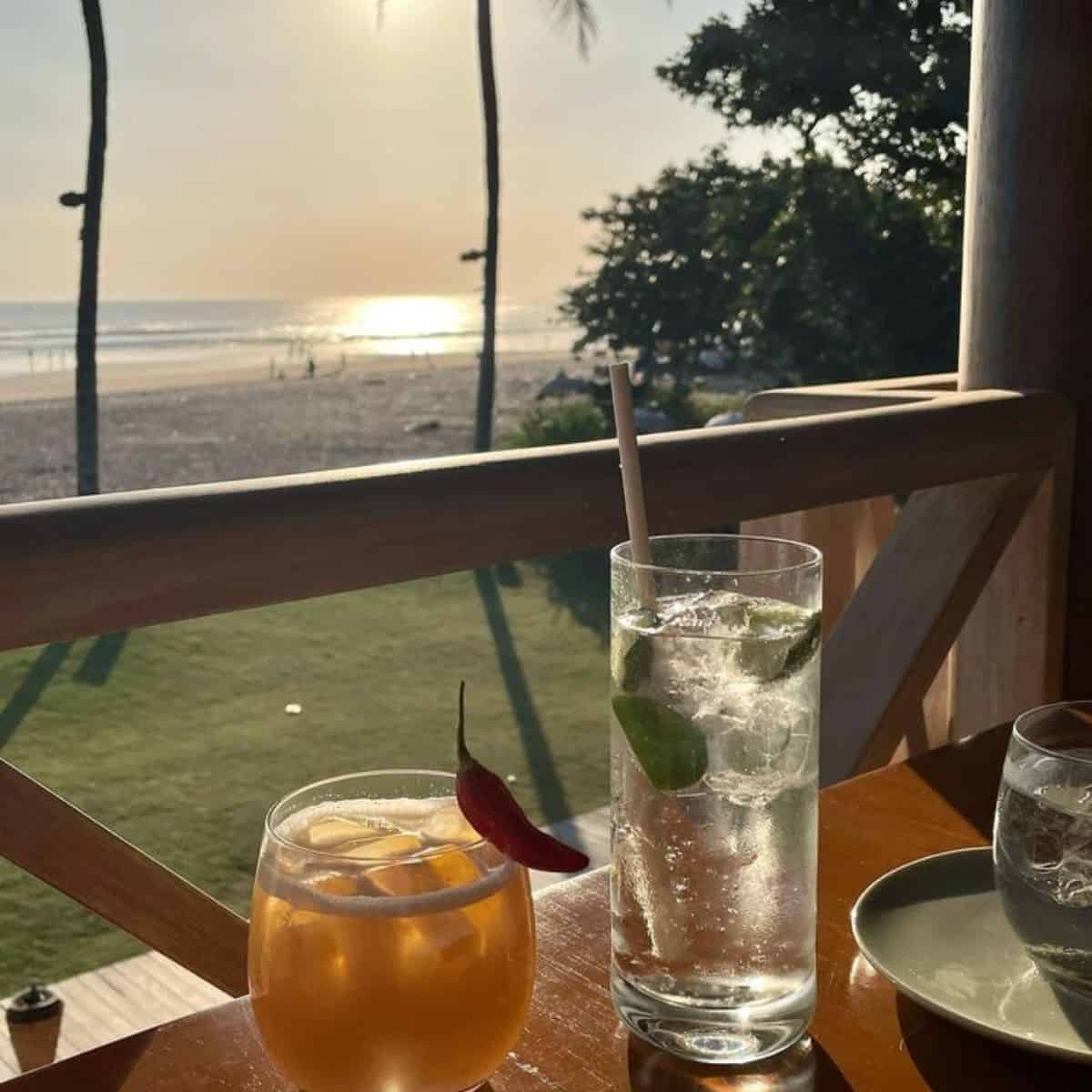 La Lucciola’s two glasses of cocktail drinks filled with ice with a calm beach in front