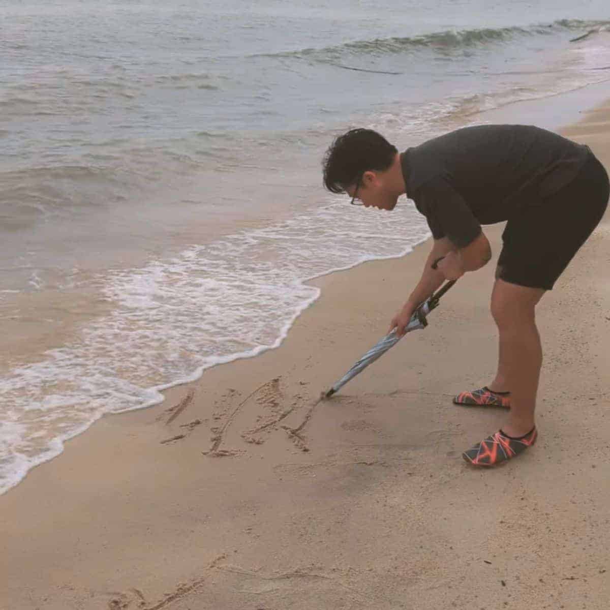 Writing in the sands before the waves catch it Penang beach