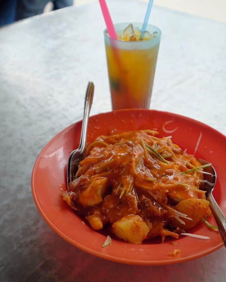 A beautiful serving of Pasembur in Kareem placed in a plastic orange plate paired with a glass of cold drink