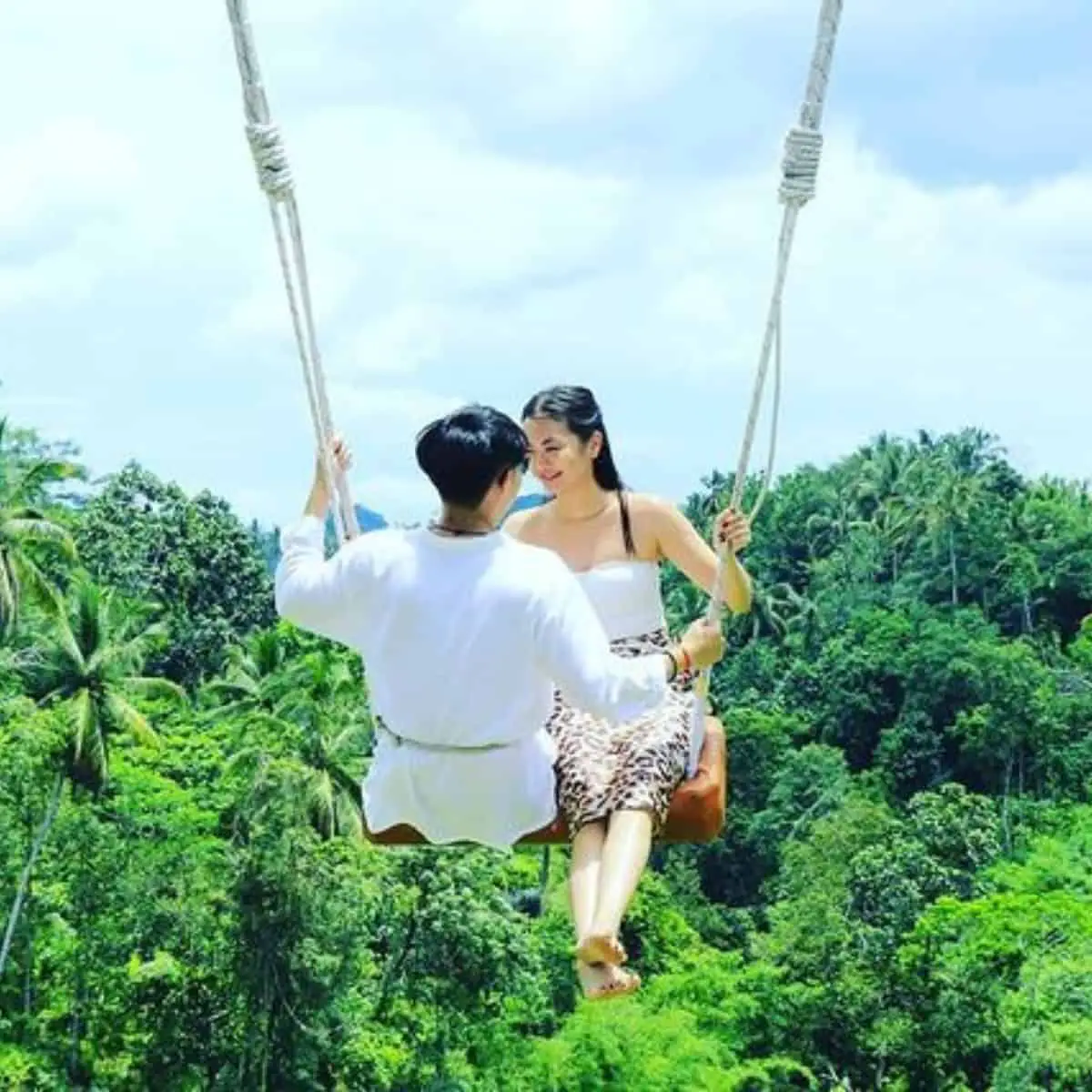 A couple in white top is enjoying their Aloha Swing ride