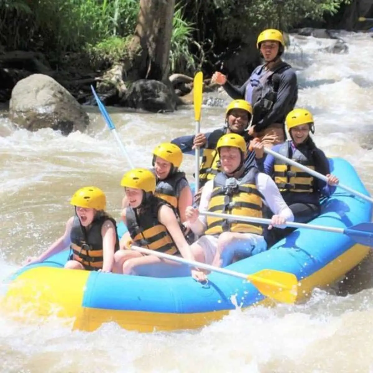 A group of people enjoying the white water rafting sport
