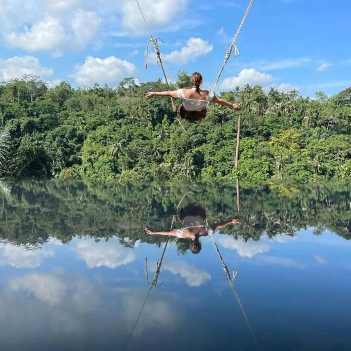 Bali Sky Swing enjoyed by a woman with river waters underneath