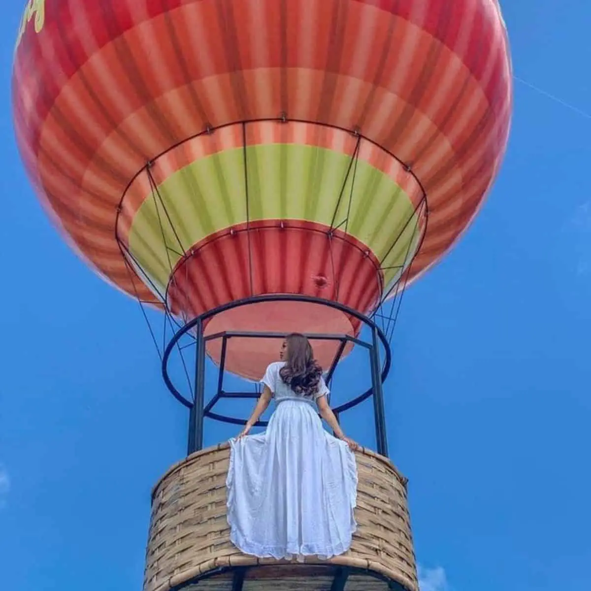 Girl in white long dress inside the hot air balloon of Happy Swing