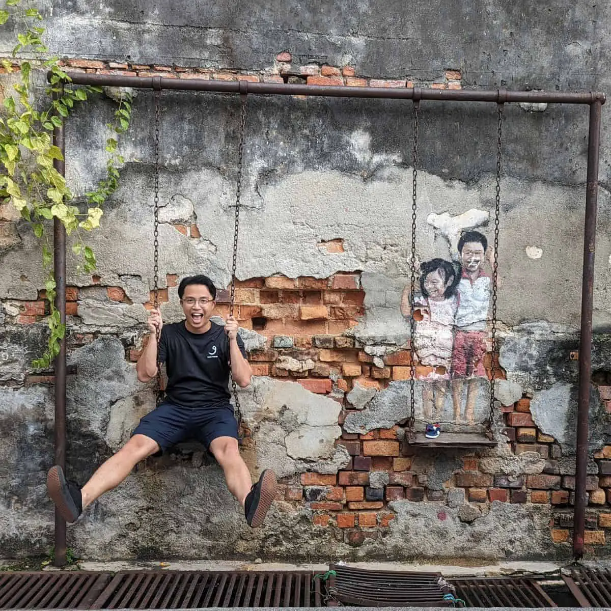 Penang Street Art in Georgetown of Brother and Sister on the Swing by Louis Gan Yee Loong
