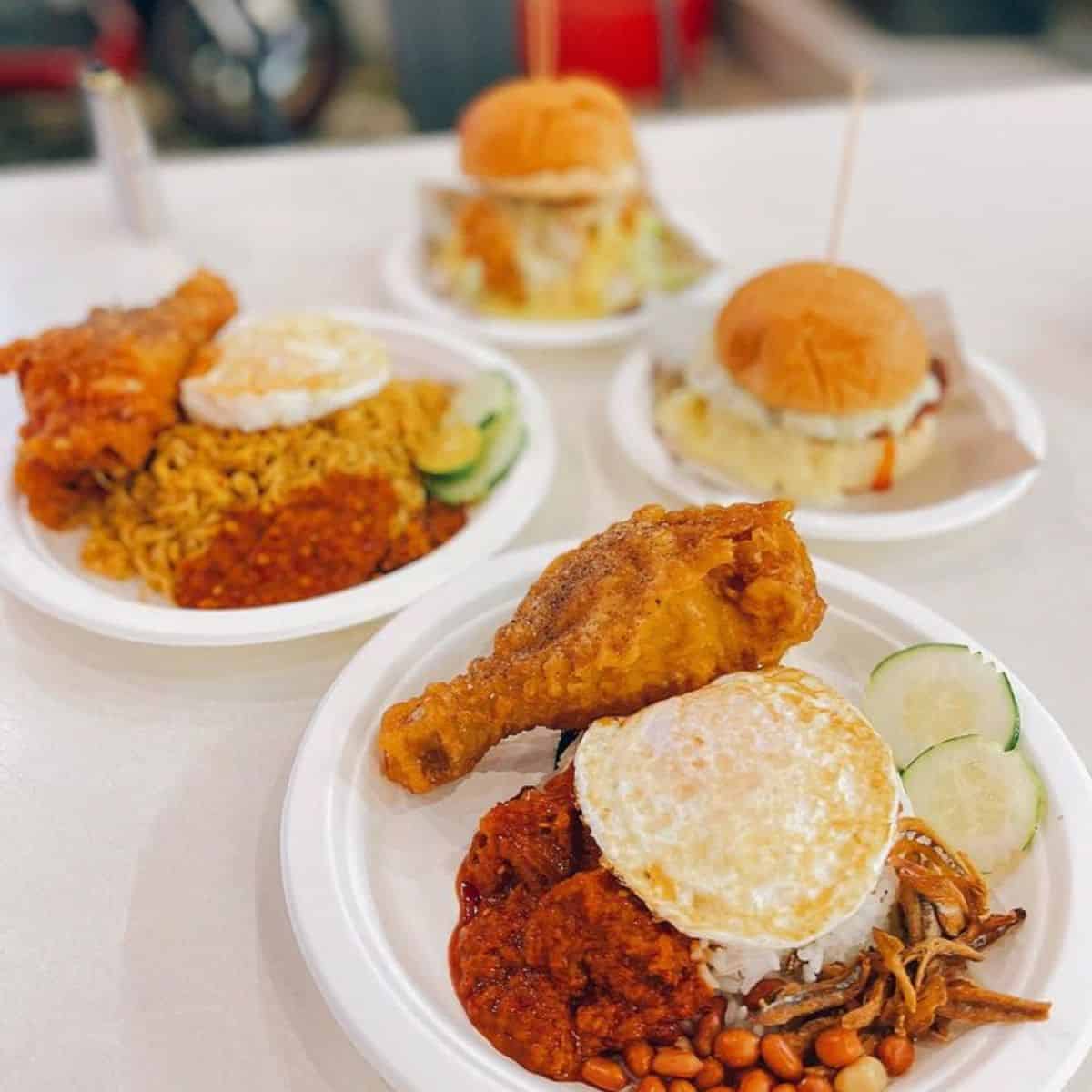 Fried chicken, salty anchovies, roasted peanuts, sliced cucumber, sambal in a saucer, and fried egg on top of white rice from Alamak