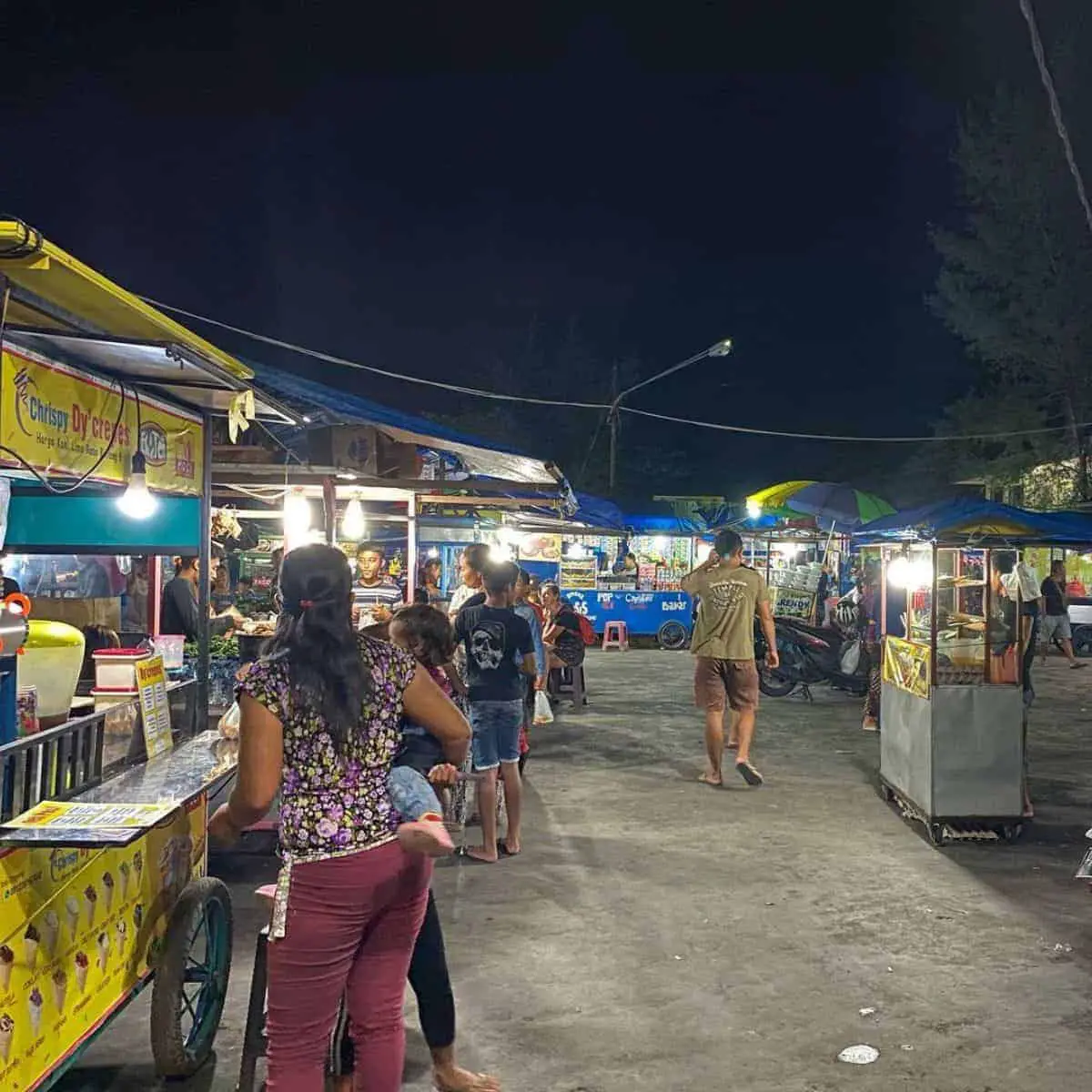 Busy street of Ubud night market with street food stalls