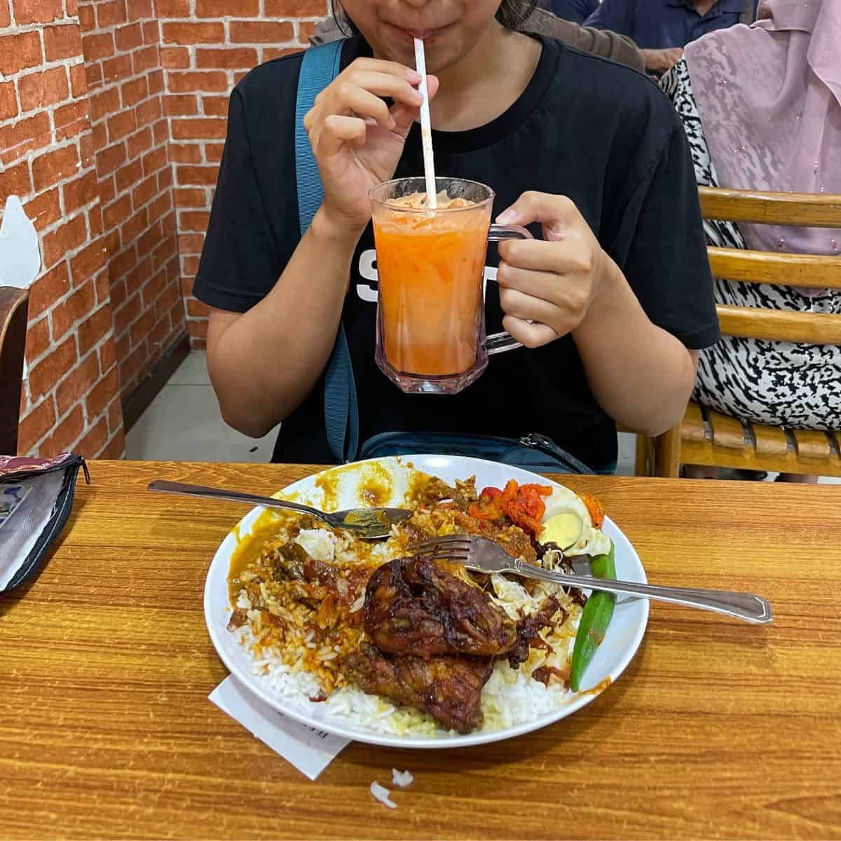 Victoria sipping on carrot milk with Hameediyah nasi kandar