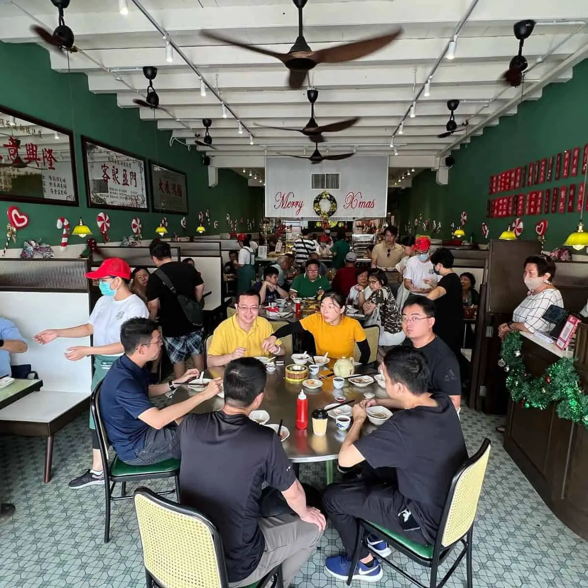 Yong Pin restaurant filled with local and tourist diners with Chinese signage in the walls