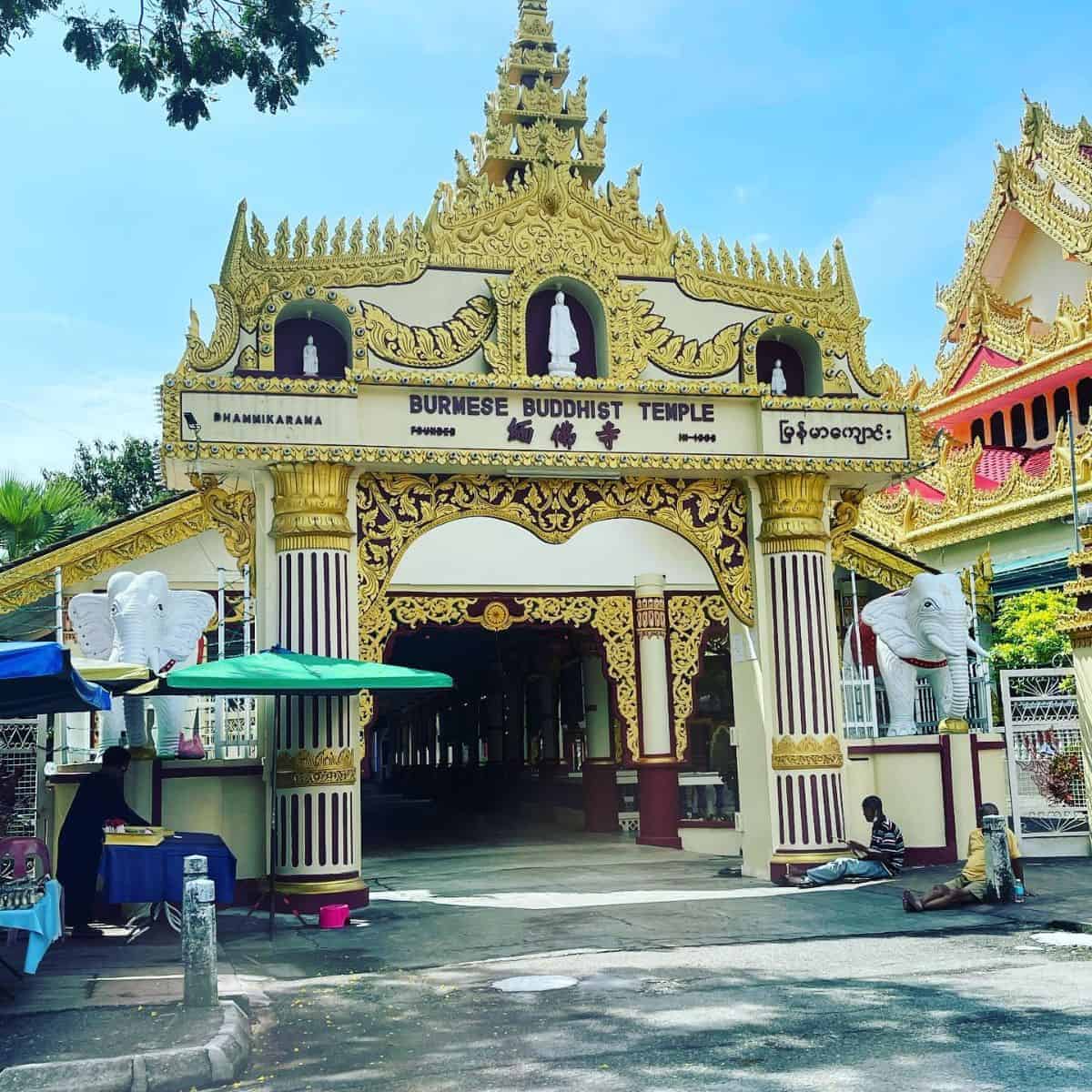 Dhammikarama in gold and white paint and statues of two white elephants, one on each side of the entrance