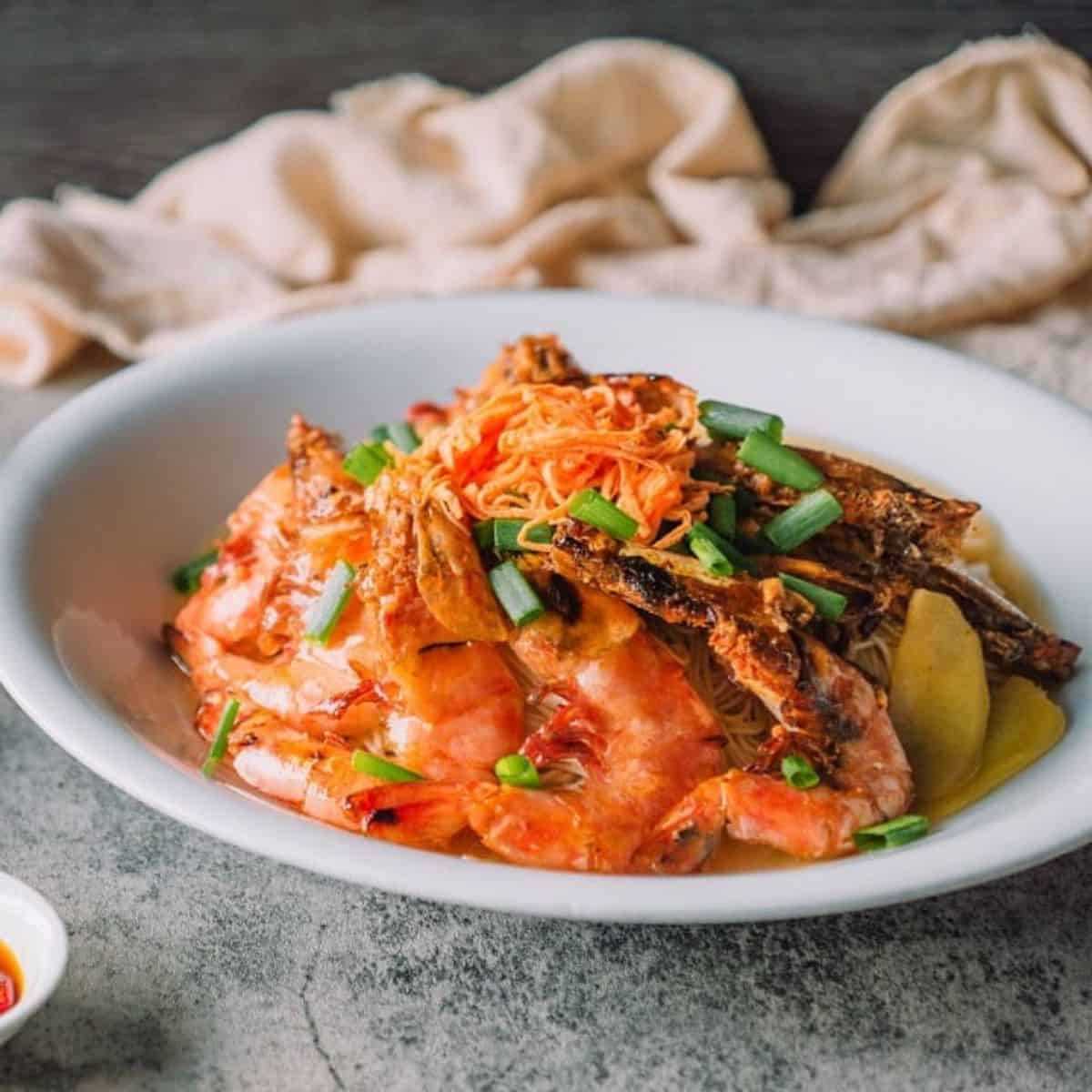 Delicious prawns in a white plate with beige linen as a table decor